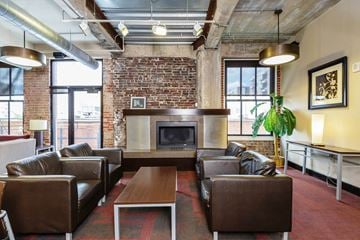 St. Louis apartment for rent - a living room with leather furniture and a brick fireplace