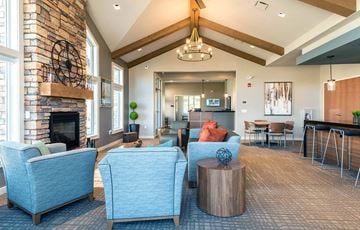 Council Bluffs apartment for rent - a living room with blue couches and chairs and a fireplace