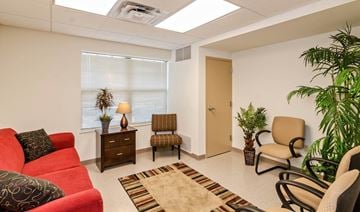 Jennings apartment for rent - a living room with a red couch and chairs and a window