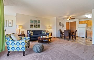 Willmar apartment for rent - a living room with a couch and a chair and a dining room table