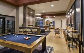 Glendale apartment for rent - A pool table is in the middle of a room with a bar and chairs.