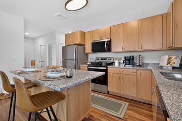 Manor apartment for rent - A kitchen with wooden cabinets and a granite countertop.
