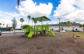 Fort Myers apartment for rent - A playground with a green slide and a green canopy.