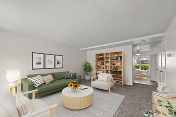 Omaha townhouse for rent - A living room with a green couch, a coffee table, and a bookshelf.