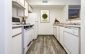 Albuquerque apartment for rent - A kitchen with white appliances and wooden floors.