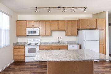 Goodyear apartment for rent - A kitchen with wooden cabinets and a granite countertop.