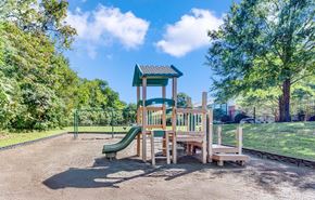 Hermitage apartment for rent - A playground with a green slide and a wooden structure.