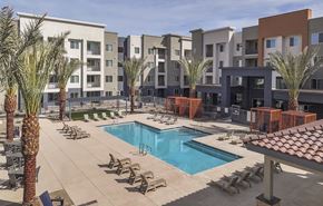 Glendale apartment for rent - A pool surrounded by palm trees and chairs in front of apartment buildings.