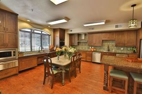 Burleson apartment for rent - a large kitchen with a large island and a table with chairs at Cedars of Elk Drive 55+ Apartments, Burleson, TX 76028