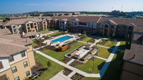 Burleson apartment for rent - an aerial view of an apartment complex with a swimming pool at Cedars of Elk Drive 55+ Apartments, Burleson, TX 76028