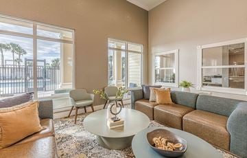 Cocoa apartment for rent - A living room with a couch, chairs, and a coffee table with a bowl of pretzels on it.