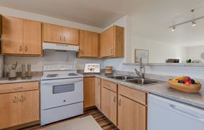 Cocoa apartment for rent - A kitchen with wooden cabinets and a white stove top oven.