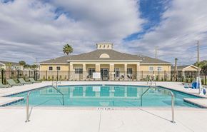 Cocoa apartment for rent - A large building with a pool in front of it.