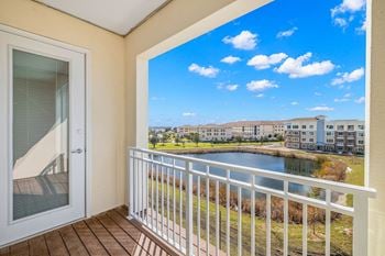 A balcony with a view of a lake and some buildings