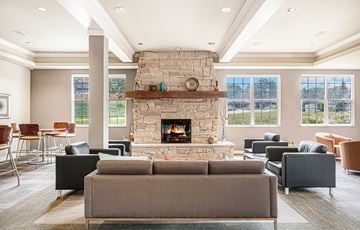 Omaha apartment for rent - a living room with couches and chairs and a stone fireplace