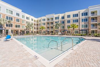 A swimming pool in front of a multi-story apartment building.