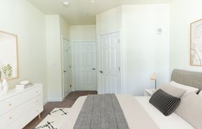 Parker apartment for rent - A white bedroom with a large bed and a dresser.