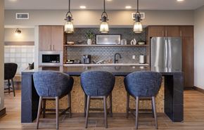 Aurora apartment for rent - A kitchen with a bar area featuring a counter and chairs.