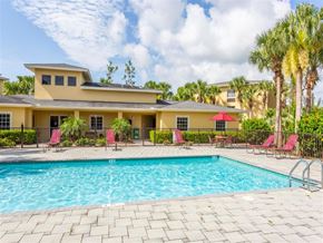 Lehigh Acres apartment for rent - A large house with a pool in front. at Heron Pond 55+ Apartments, Lehigh Acres, FL