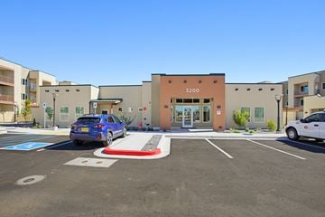 Rio Rancho apartment for rent - A blue car is parked in a parking lot in front of a building with the number 3200 on it.