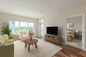 Greenville apartment for rent - A living room with a green couch, a wooden coffee table, and a flat screen TV. at Avery Landing Apartments, South Carolina