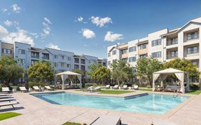 Surprise apartment for rent - A swimming pool surrounded by lounge chairs and umbrellas in front of apartment buildings at Orchard Springs 55+ Apartment , Surprise, 85374