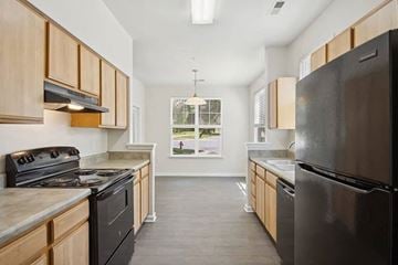 Durham apartment for rent - A kitchen with black appliances and wooden cabinets.