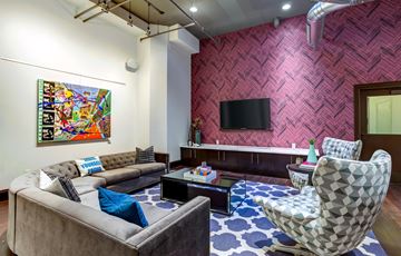 St Louis apartment for rent - A living room with a grey couch and a patterned chair.