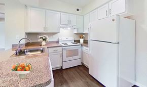 Ypsilanti apartment for rent - Contempo kitchen with sleek white cabinetry, white appliances, dishwasher, bistro bar, granite countertops and easy-care wood plank flooring.