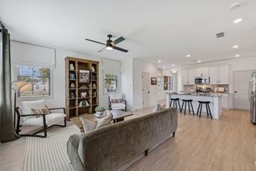 Dawsonville townhouse for rent - A living room with a grey couch and a ceiling fan.