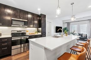 Marble Falls apartment for rent - A modern kitchen with dark wood cabinets and a white island.