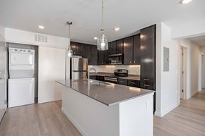 Jarrell apartment for rent - A modern kitchen with a white island and dark brown cabinets.