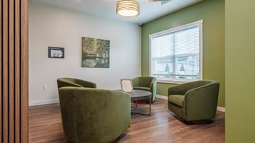 East Patchogue apartment for rent - A living room with green chairs and a painting on the wall.