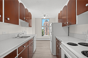 Calgary apartment for rent - A kitchen with brown cabinets and a white stove top oven.