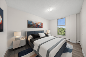 Calgary apartment for rent - A bedroom with a large bed and a painting on the wall.