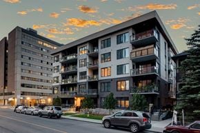Calgary apartment for rent - A modern apartment building with cars parked in front.