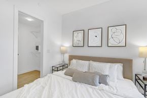 Calgary apartment for rent - A bedroom with a large bed and three framed artworks on the wall.