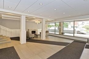 Calgary apartment for rent - A spacious lobby with a staircase and a fireplace.