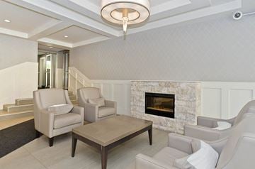 Calgary apartment for rent - A living room with a fireplace and two chairs.