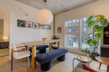 Edmonton apartment for rent - A living room with a white table and blue ottoman.