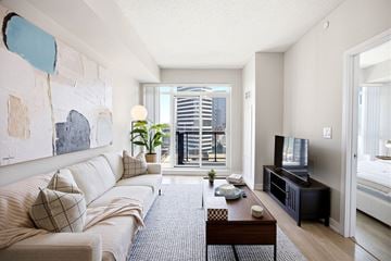 Toronto apartment for rent - A living room with a couch, a coffee table, and a television.