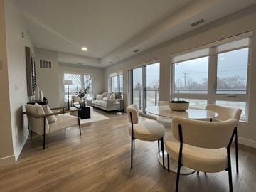 Niagara Falls apartment for rent - A living room with white furniture and a large window.