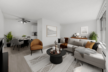 Calgary apartment for rent - A modern living room with a grey sofa, a coffee table, and a dining table with chairs.