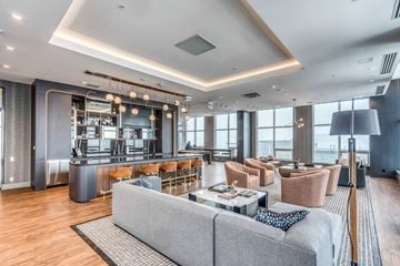 Calgary apartment for rent - A modern living room with a grey sofa and a wooden floor.