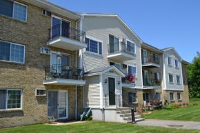 Somersworth apartment for rent - A multi-story apartment building with balconies and flower pots.