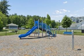 Merrimack apartment for rent - A playground with a blue slide and a grey gravel ground.