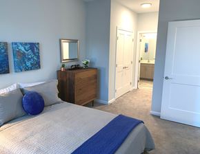 Somersworth apartment for rent - A bedroom with a bed, nightstand, and two paintings on the wall.