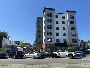 Concord apartment for rent - a tall building with cars parked in front of it on a city street