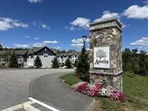 Nashua townhouse for rent - A stone pillar with a sign that says Amelia in front of a road.
