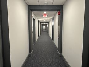 Concord apartment for rent - a hallway with a carpeted floor and black and white walls and a long corridor
